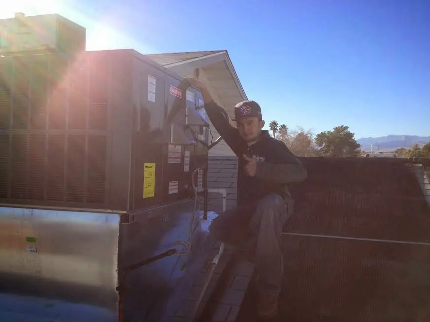 HVAC technician performing Air Duct Cleaning on a rooftop unit in Granby